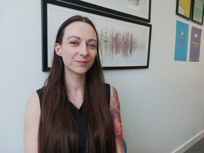 A photograph of See Me volunteer Lisa, a young white woman with long dark hair.